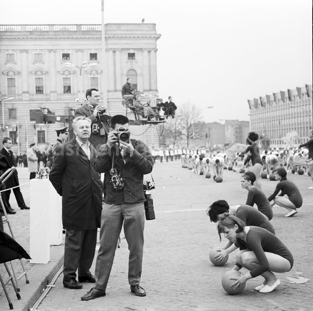 GDR photo archive: Berlin Mitte - Media representatives - Photographer at a GDR- soldier in front of the grandstand at 1 May, Schlossplatz in Berlin - Mitte