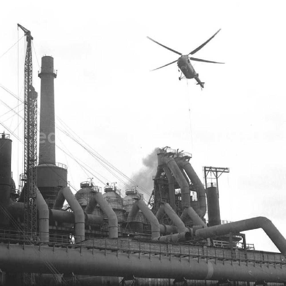 GDR photo archive: Eisenhüttenstadt - Mi-4 Hubschrauber mit der Kennung DM-SPE fliegt über die Produktionsanlagen vom VEB Bandstahlkombinat Hermann Matern.