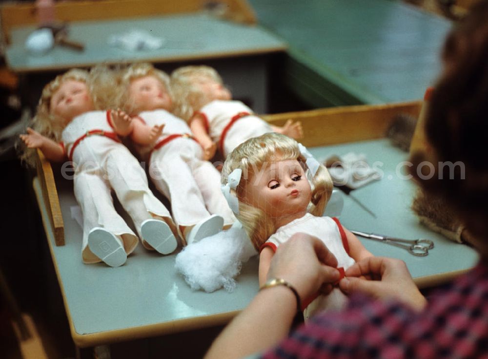 GDR picture archive: Sonneberg - Eine Mitarbeiterin des VEB Kombinat Spielwaren Sonneberg sonni verpackt die fertigen Puppen in ein Netz. Die Sonneberger Puppen waren nicht nur in der DDR beliebt, sondern trugen den Namen der Stadt in alle Welt.