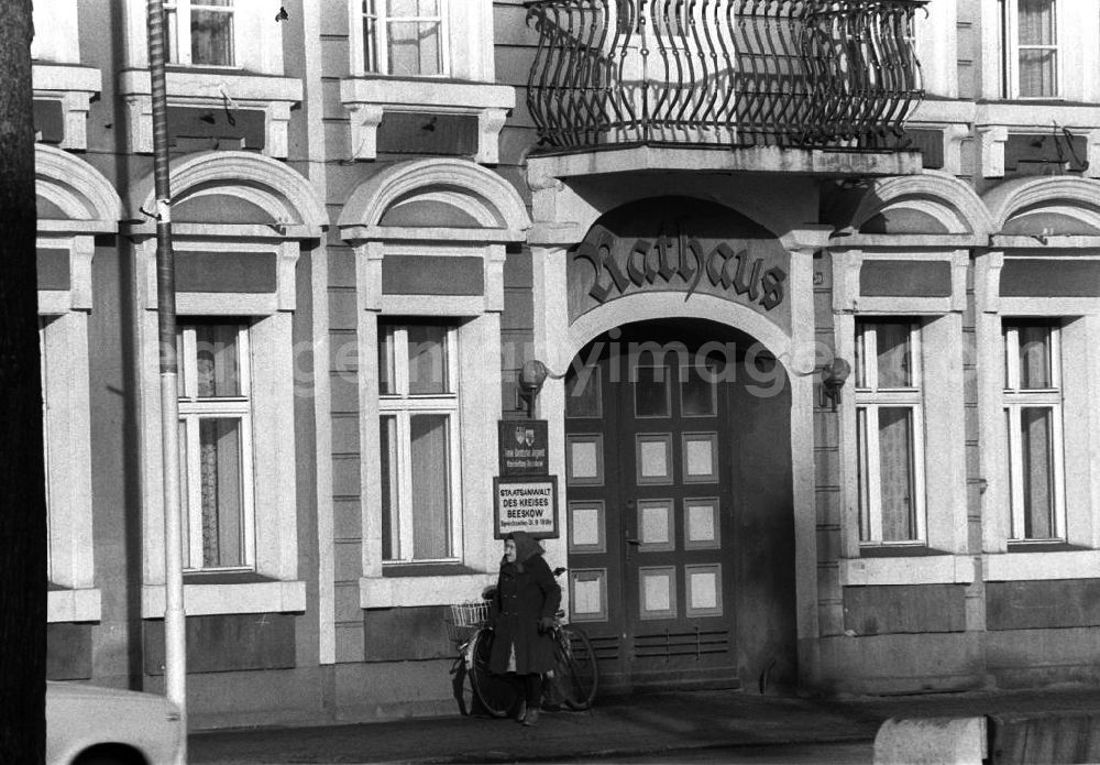 Beeskow: Hauseingang vom Rathaus Beeskow, eine Rentnerin / Seniorin mit Kopftuch geht vor dem Rathaus auf dem Gehweg spazieren.