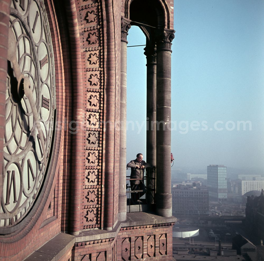 Berlin: Man on the gallery of the tower at the building of the city hall of the city administration with the face of the tower clock of the Red City Hall in the district Mitte in Berlin East Berlin in the area of the former GDR, German Democratic Republic
