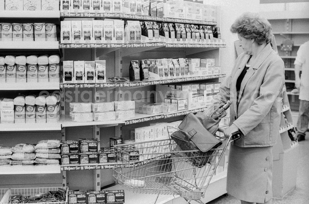 GDR image archive: Berlin - A woman shopping in a department store in Berlin, the former capital of the GDR, the German Democratic Republic. The shelves are filled partly with East products as well with Western products
