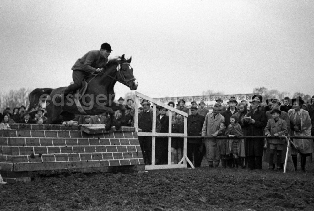 GDR picture archive: Leipzig - Rider jumps with his horse over a wall during the riding and driving competition at the Scheibenholz racecourse in Leipzig in the state Saxony on the territory of the former GDR, German Democratic Republic