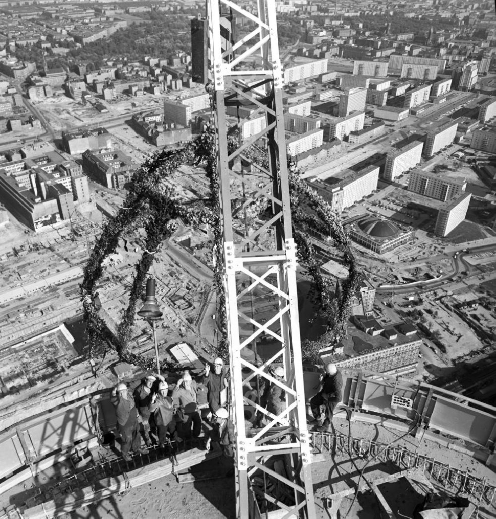 GDR picture archive: Berlin-Mitte - Der Rohbau des Berliner Fernsehturms am Alexanderplatz in Berlin-Mitte ist fertiggestellt und so wird Richtfest gefeiert und dem neuen Bauwerk traditionell der Richtkranz aufgesetzt. Genau zwei Jahre später konnte das über 30
