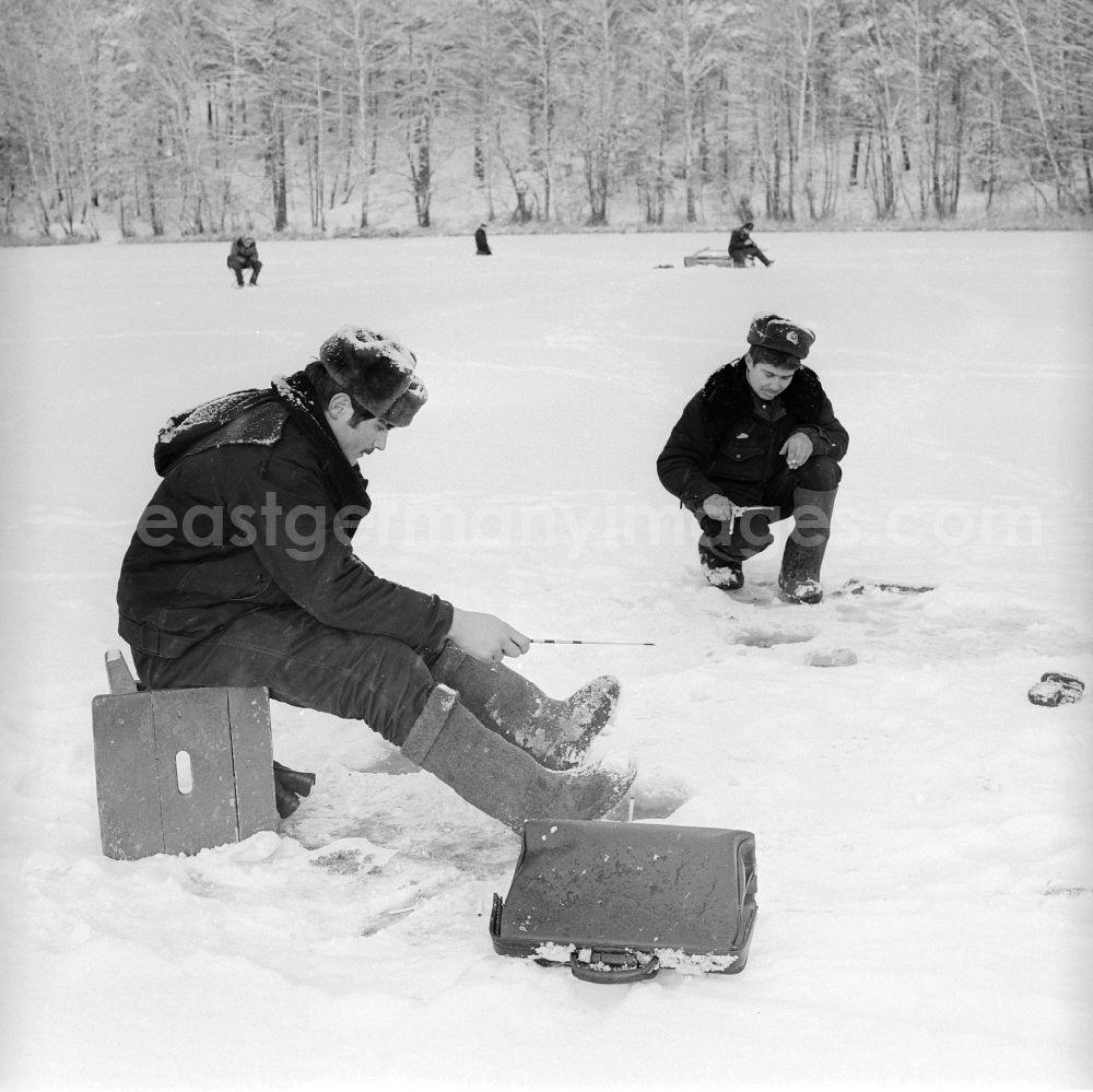 Wittstock/Dosse: Russian soldiers in winter uniforms with the ice fish on the small Baalsee in Wittstock / Dosse in the federal state Brandenburg in the area of the former GDR, German democratic republic