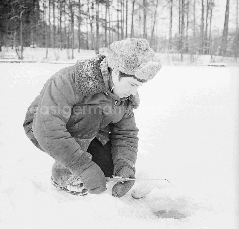 GDR picture archive: Wittstock/Dosse - Russian soldier in winter uniform with the ice fish on the small Baalsee in Wittstock / Dosse in the federal state Brandenburg in the area of the former GDR, German democratic republic