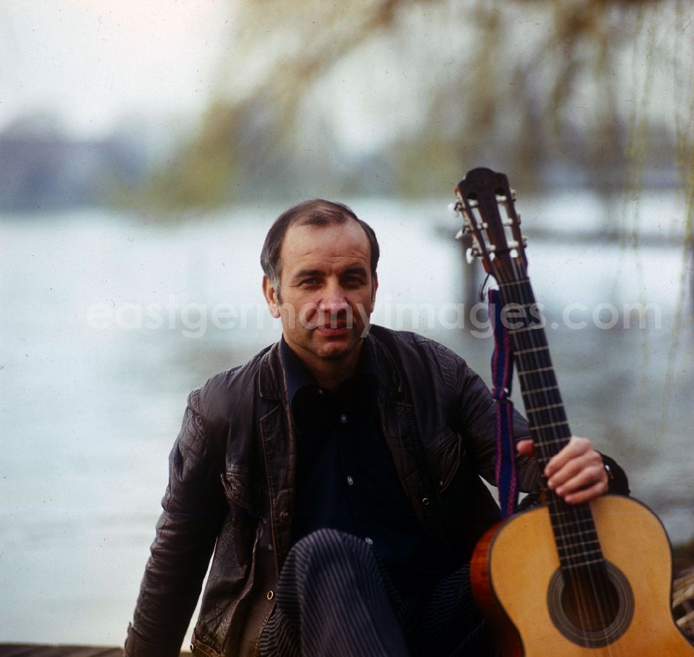 GDR image archive: Berlin - Actor Armin Mueller-Stahl in the guitar playing on the banks of the Dahme River in Berlin - Koepenick