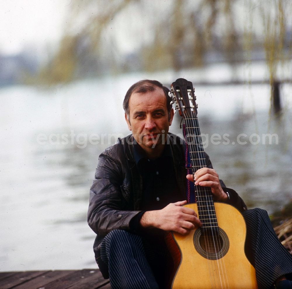 GDR photo archive: Berlin - Actor Armin Mueller-Stahl in the guitar playing on the banks of the Dahme River in Berlin - Koepenick