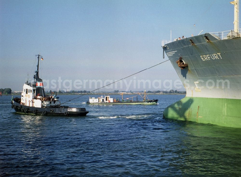 GDR photo archive: Rostock - Ship MS Erfurt Typ Meridian II mit Schlepper underway at the quays in the port area in Rostock in the state Mecklenburg-Western Pomerania on the territory of the former GDR, German Democratic Republic