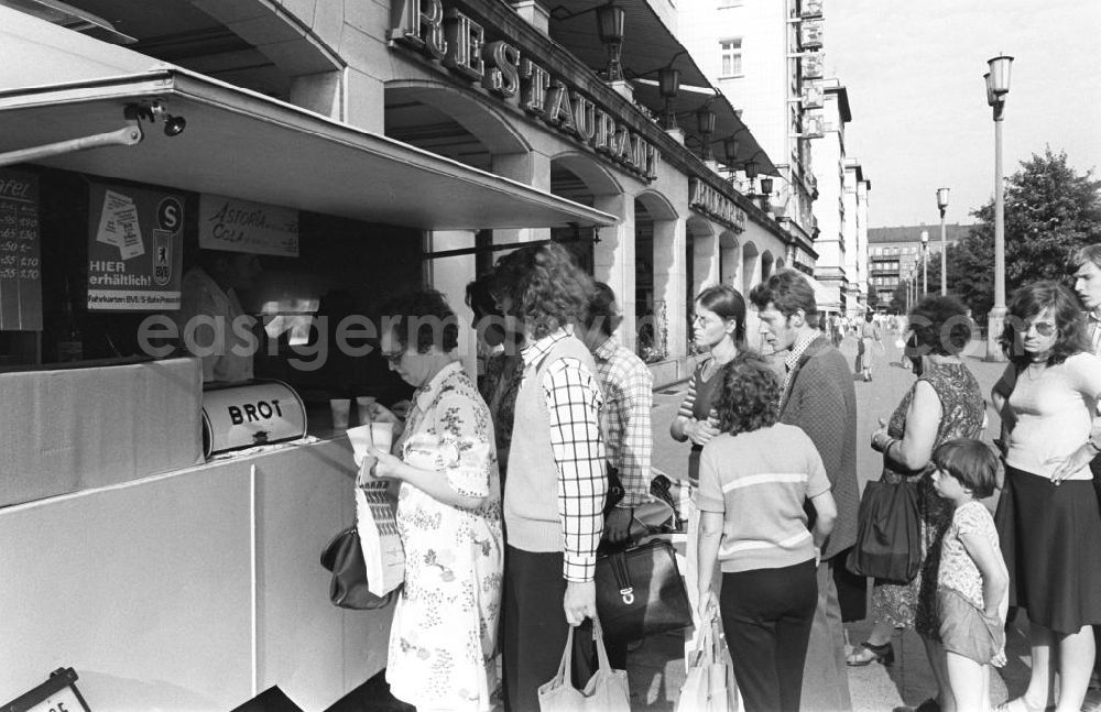 GDR picture archive: Berlin - Die Schlange steht nicht nur an dem Imbiß-Kiosk vor dem Restaurant Bukarest unweit vom Frankfurter Tor, sie ist normal. Da sich die Zahl derartiger Angebote noch in Grenzen hält, sind Wartezeiten einzuplanen.