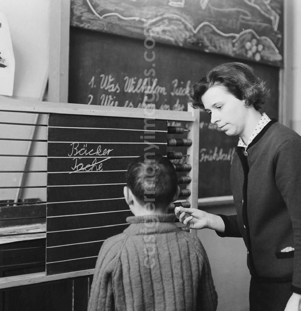 GDR picture archive: Berlin - Students of the lower level with his teacher at blackboard teaching of German in Berlin. The German-classes were divided into four separate subjects: reading, writing, spelling and grammar, as well as oral and written expression