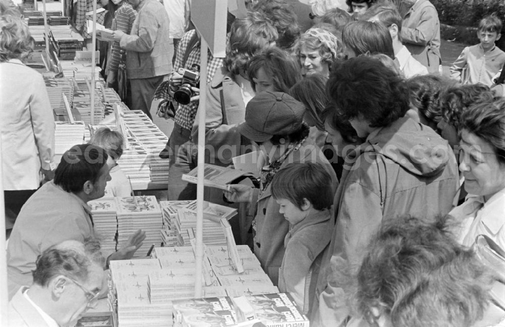 Erfurt: Writers' bazaar on the grounds of the IGA in the Rose Garden on the occasion of the 15th Workers' Festival in Erfurt in the federal state of Thuringia in the territory of the former GDR, German Democratic Republic. Guenter Hofé ( left in front, author ) and Heinz Knobloch ( left behind, author and feature writer ) sign their books at the book bazaar
