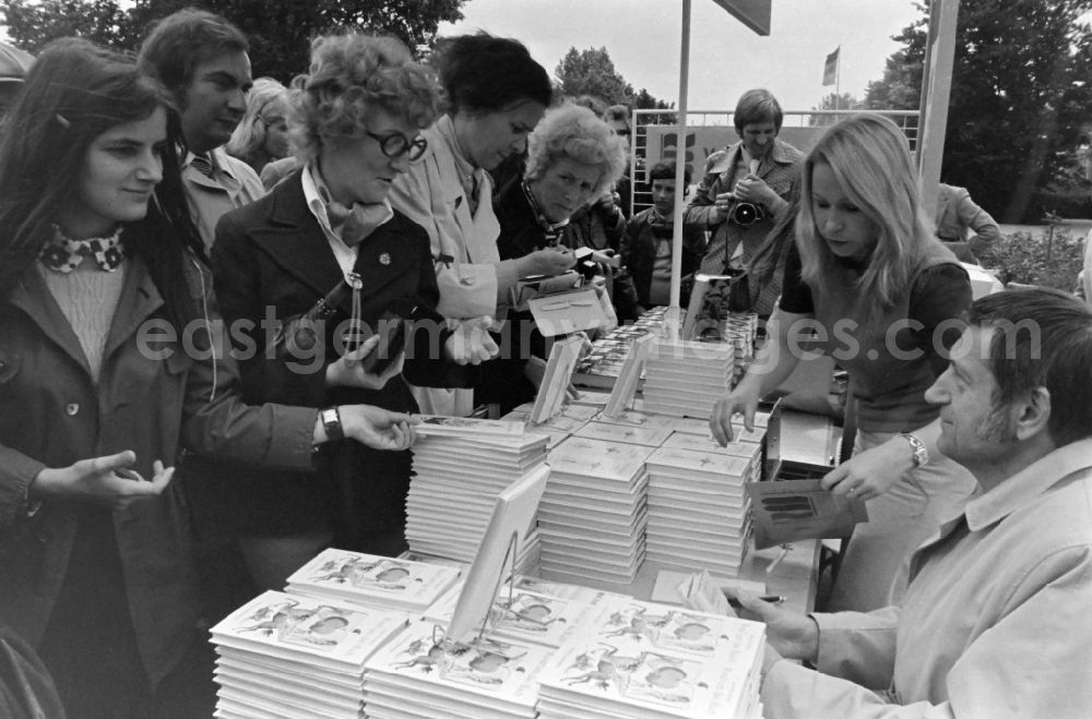 GDR picture archive: Erfurt - Writers' bazaar on the grounds of the IGA in the Rose Garden on the occasion of the 15th Workers' Festival in Erfurt in the federal state of Thuringia in the territory of the former GDR, German Democratic Republic. Heinz Knobloch ( author and feature writer ) signs one of his books at the book bazaar