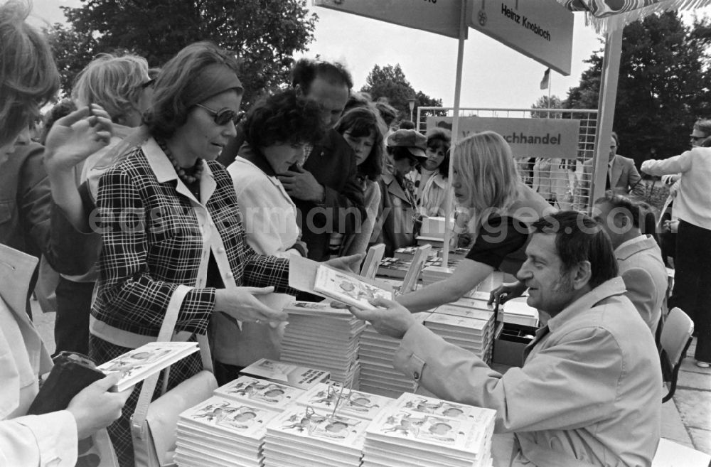 Erfurt: Writers' bazaar on the grounds of the IGA in the Rose Garden on the occasion of the 15th Workers' Festival in Erfurt in the federal state of Thuringia in the territory of the former GDR, German Democratic Republic. Heinz Knobloch ( author and feature writer ) signs one of his books at the book bazaar