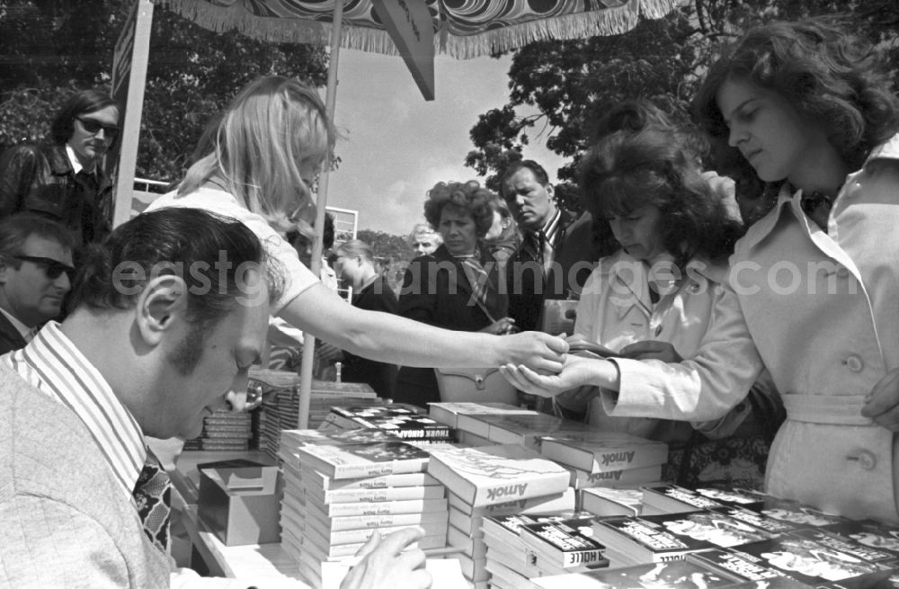 GDR photo archive: Erfurt - Writers' bazaar on the grounds of the IGA in the Rose Garden on the occasion of the 15th Workers' Festival in Erfurt in the federal state of Thuringia in the territory of the former GDR, German Democratic Republic. Harry Thuerk ( one of the most read authors in the GDR ) signs his book The Tiger of Shangri-La and other works at the book bazaar
