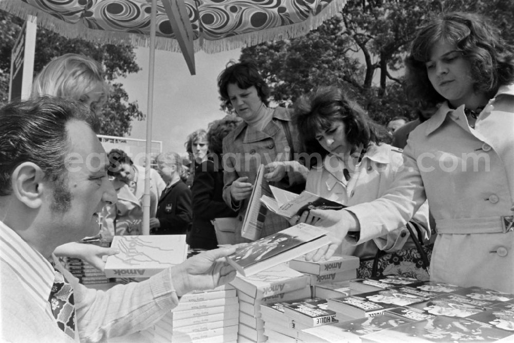 GDR picture archive: Erfurt - Writers' bazaar on the grounds of the IGA in the Rose Garden on the occasion of the 15th Workers' Festival in Erfurt in the federal state of Thuringia in the territory of the former GDR, German Democratic Republic. Harry Thuerk ( one of the most read authors in the GDR ) signs his book The Tiger of Shangri-La and other works at the book bazaar