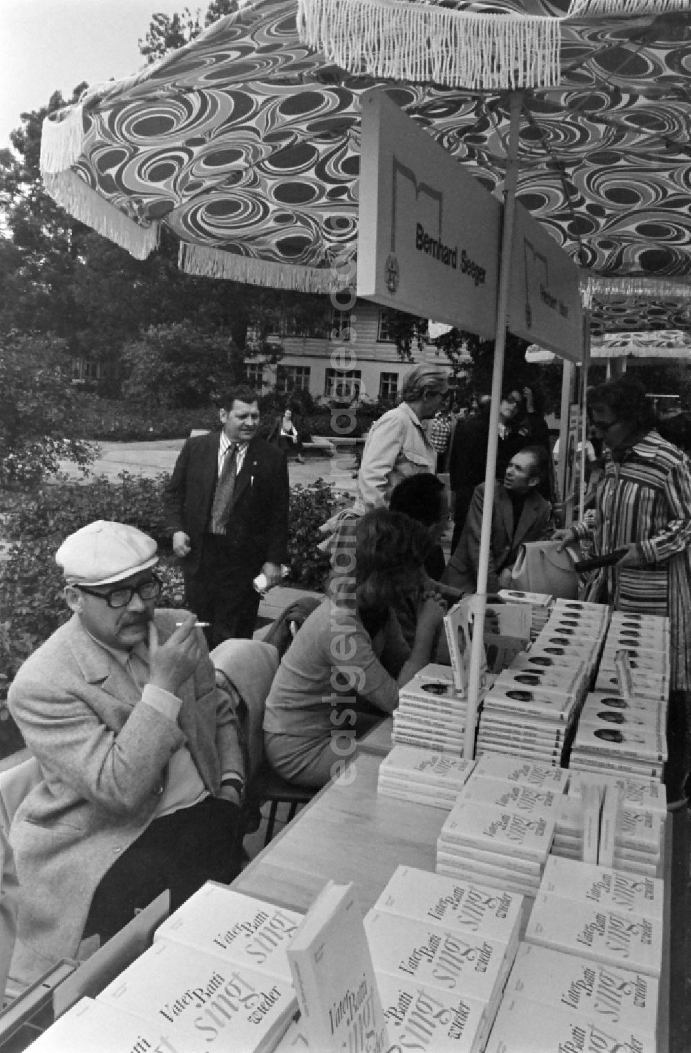 Erfurt: Writers' bazaar on the grounds of the IGA in the Rose Garden on the occasion of the 15th Workers' Festival in Erfurt in the federal state of Thuringia in the territory of the former GDR, German Democratic Republic. Bernhard Seeger ( author ) with his books at the book bazaar