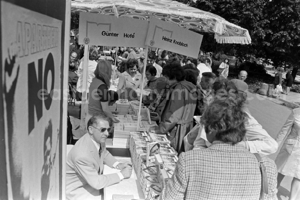 GDR image archive: Erfurt - Writers' bazaar on the grounds of the IGA in the Rose Garden on the occasion of the 15th Workers' Festival in Erfurt in the federal state of Thuringia in the territory of the former GDR, German Democratic Republic. Guenter Hofé ( author ) with his books at the book bazaar