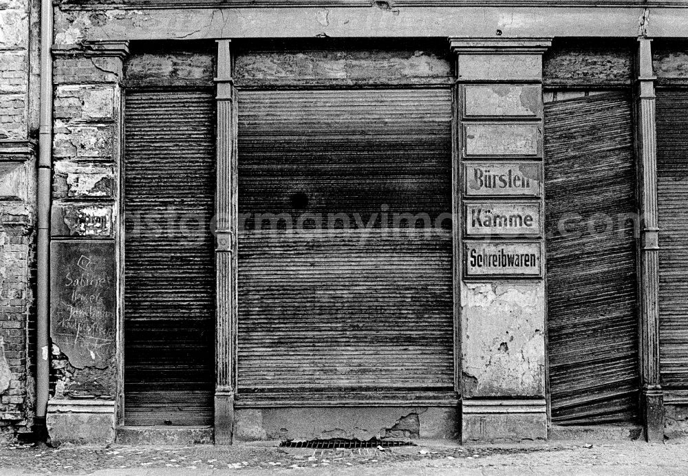 GDR picture archive: Berlin - Fading lettering in the entrance area and shop window of a retail store Brushes - Combs - Stationery in the street area of an old residential building facade in the Prenzlauer Berg district of Berlin East Berlin in the area of the former GDR, German Democratic Republic