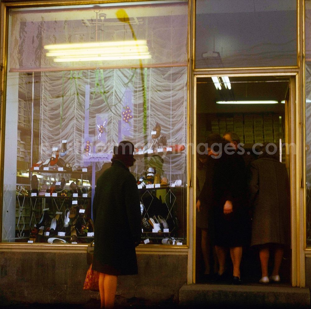 GDR image archive: Berlin - A woman looks to herself the new spring collection in the shop-window of a shoe store in in Berlin, the former capital of the GDR, German democratic republic