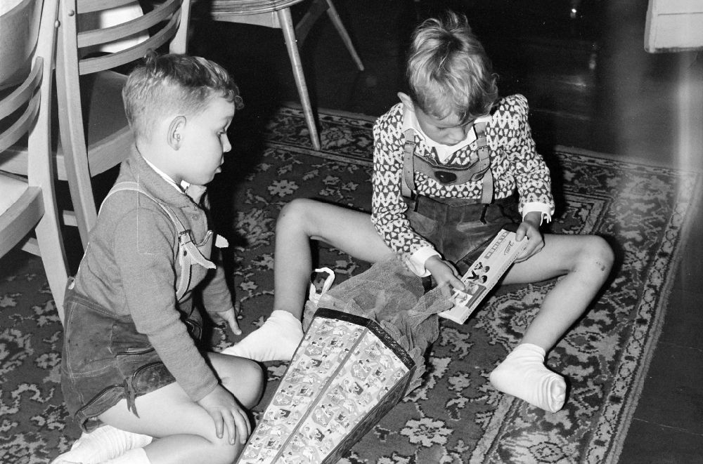 GDR photo archive: Berlin - Children unpacking the sugar bag on the occasion of the start of school in a living room on Florastrasse in the Pankow district of Berlin East Berlin in the territory of the former GDR, German Democratic Republic