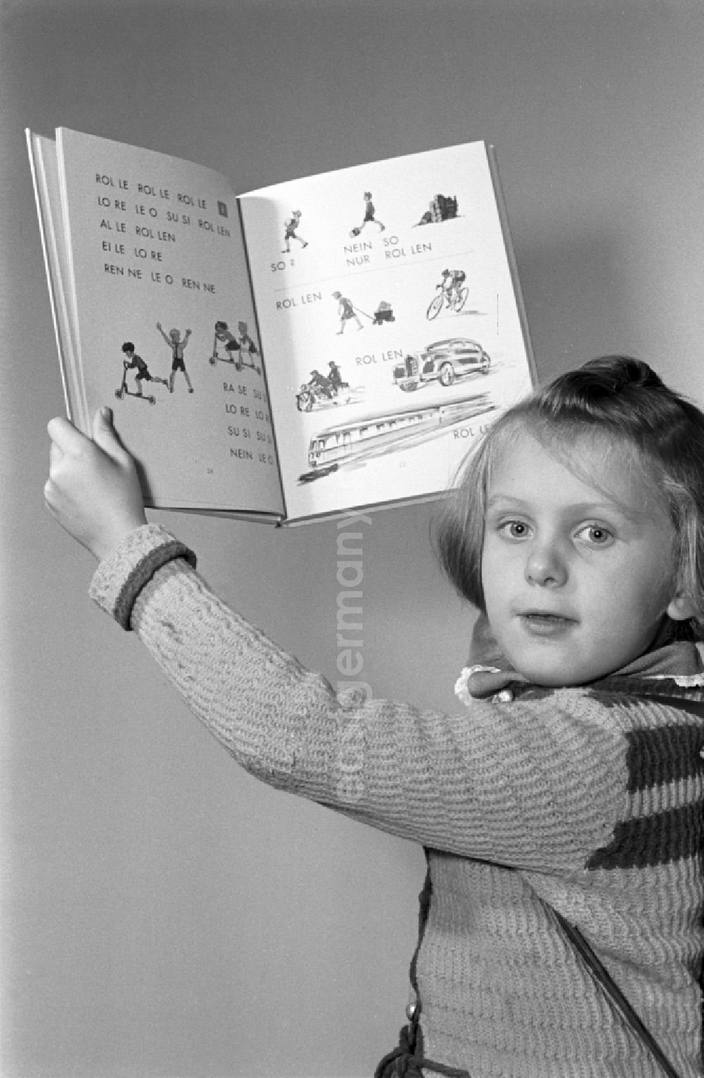 GDR picture archive: Dresden - Children on the occasion of the start of school for two young girls enthusiastically looking at a school book on the German language Unsere Fiebel in the district of Altstadt in Dresden in the state of Saxony on the territory of the former GDR, German Democratic Republic