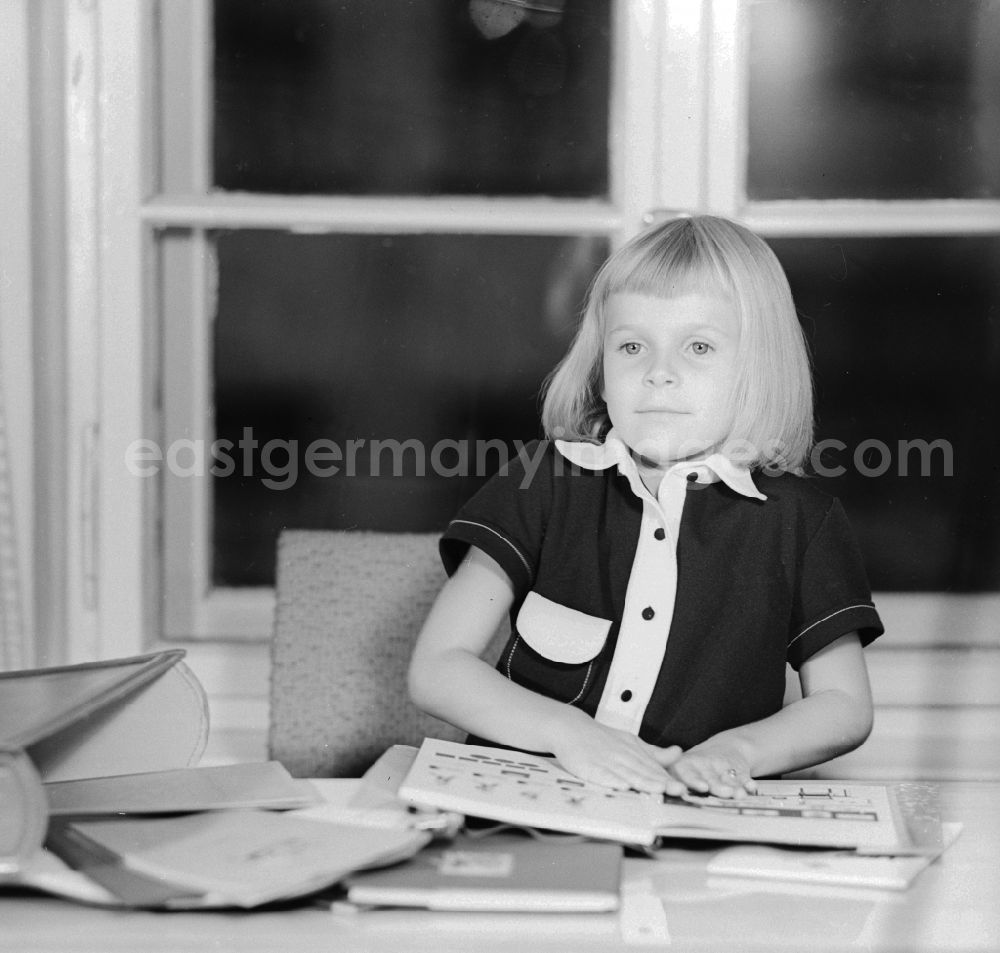 GDR picture archive: Berlin - 1st day of school - girl proudly displays her first math book in Berlin, the former capital of the GDR, the German Democratic Republic