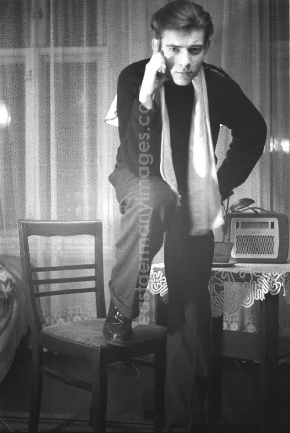 GDR image archive: Leipzig - Frühes Selbstportrait des Fotografen Klaus Morgenstern. Morgenstern, lässig bis elegant gekleidet, posiert mit einem Stuhl. Auf einem beistehenden Tisch ein Radiogerät der 5