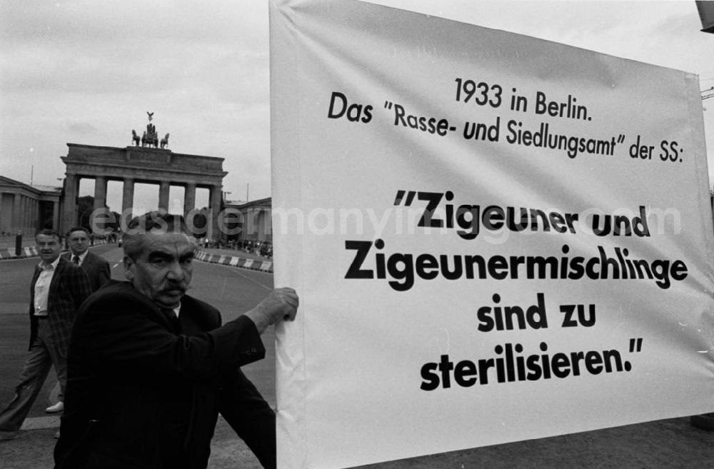 GDR image archive: Berlin-Mitte - Sintis und Roma demonstrieren auf dem Pariser Platz vor dem Brandenburger Tor. Demonstrant hält Plakat mit der Aufschrift Zigeuner und Zigeunermischlinge sind zu sterilisieren..