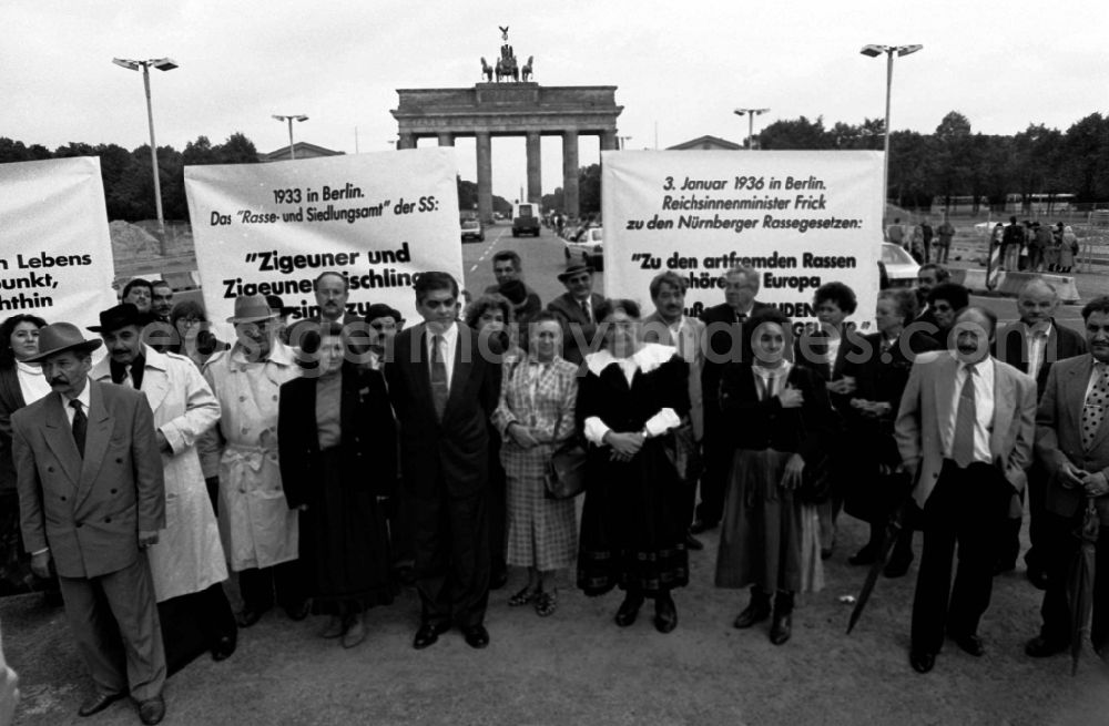 GDR photo archive: Berlin - Sintis and Roma demonstrate on Pariser Platz in front of the Brandenburg Gate in the Mitte district of Berlin. Demonstrators stand together and hold placards