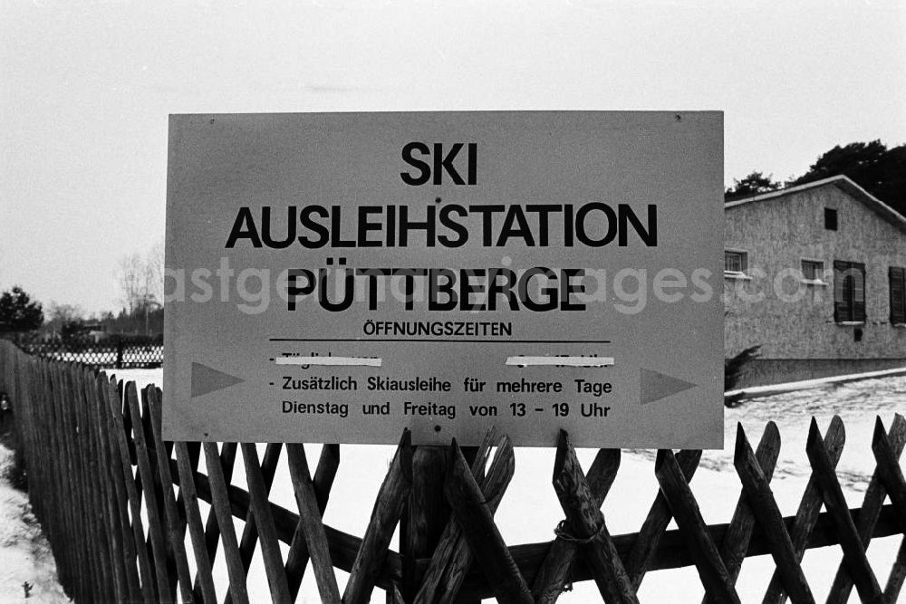 GDR photo archive: Berlin - Nah: Schild der Ski Ausleihstation Püttberge in Berlin-Wilhelmshagen. Die hier lagernden Abfahrts- und Langlaufski sind in der Regel nicht für den sofortigen Gebrauch in dem hügligen Gelände am östlichen Stadtrand Berlins gedacht, sondern für die Urlaubsreise nach Thüringen oder in das Erzgebirge.