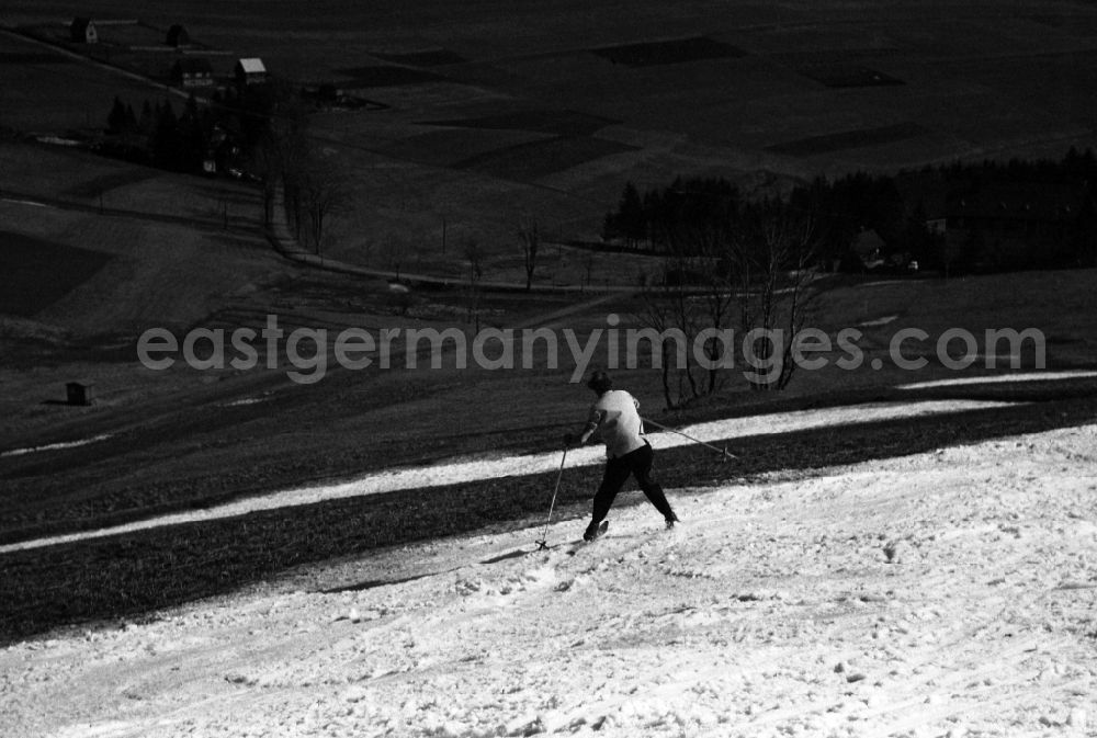 GDR picture archive: Oberwiesenthal - Skiers on a snow-covered slope on the Fichtelberg mountain in Oberwiesenthal in the state Saxony on the territory of the former GDR, German Democratic Republic