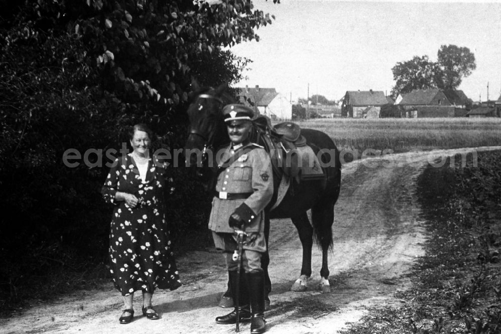 GDR image archive: Leuna - A soldier of the armed forces with saber,horse and his wife in Leuna in the federal state Saxony-Anhalt in Germany