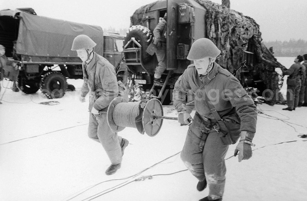 GDR image archive: Königs Wusterhausen - Soldiers of the 2nd news regiment of the NVA with roll out from news cable during a manoeuvre in winter in Wernsdorf in Koenigs Wusterhausen in the federal state Brandenburg in the area of the former GDR, German democratic republic