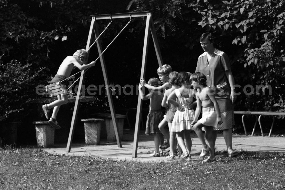Berlin: Summer temperatures while playing and having fun with toddlers cared for by educators in a kindergarten on a playground in Berlin East Berlin on the territory of the former GDR, German Democratic Republic