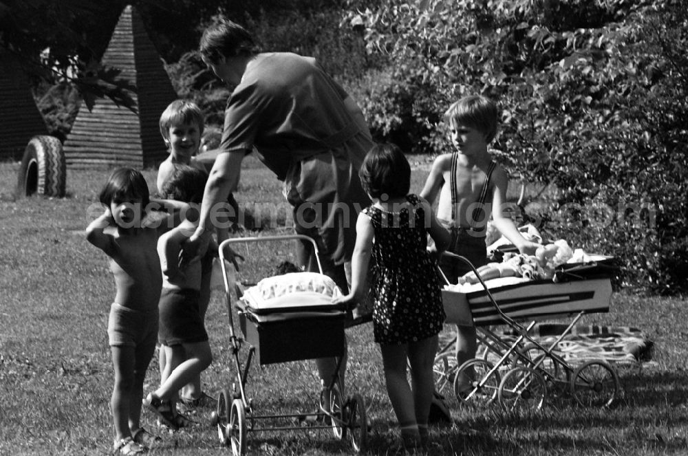GDR image archive: Berlin - Summer temperatures while playing and having fun with toddlers cared for by educators in a kindergarten on a playground in Berlin East Berlin on the territory of the former GDR, German Democratic Republic