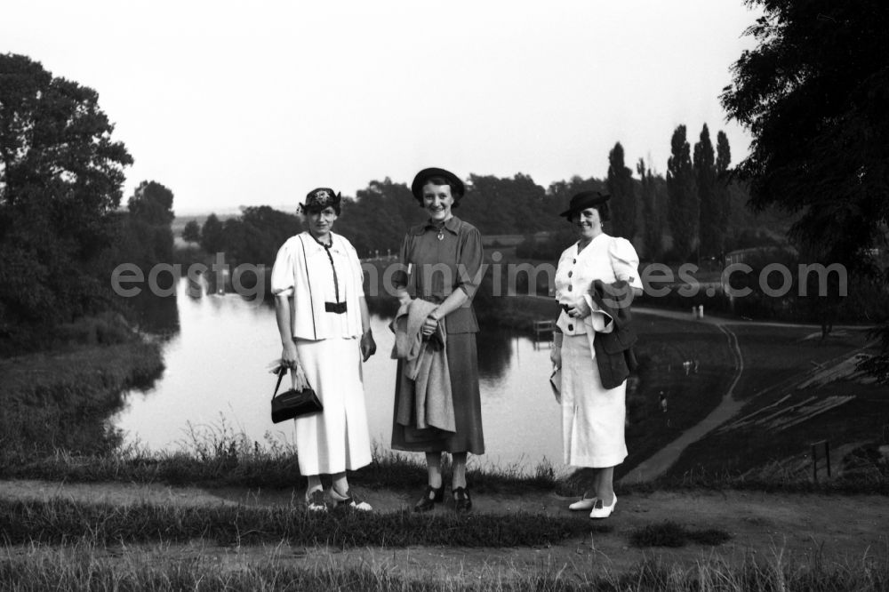Leuna: Three women go for a Sunday walk in Leuna in the federal state Saxony-Anhalt in Germany. In the background the Leuna works