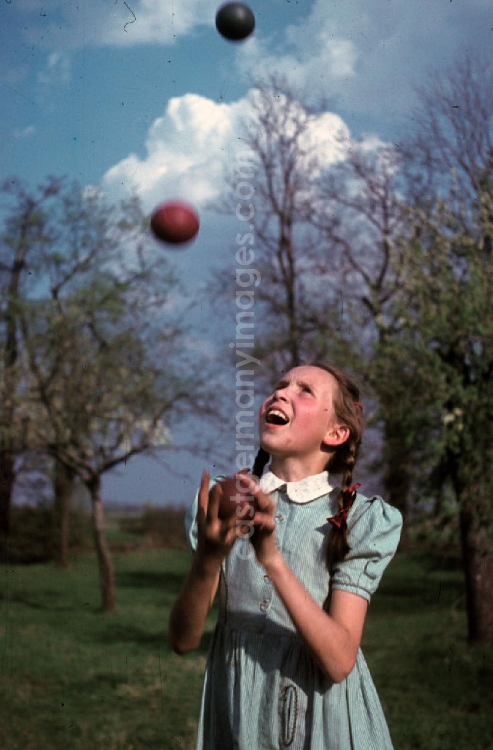 GDR picture archive: Bad Godesberg - Ein Mädchen jongliert mit drei Bällen in einem Park in Bad Godesberg. A girl juggling with three balls in a park in Bad Godesberg.