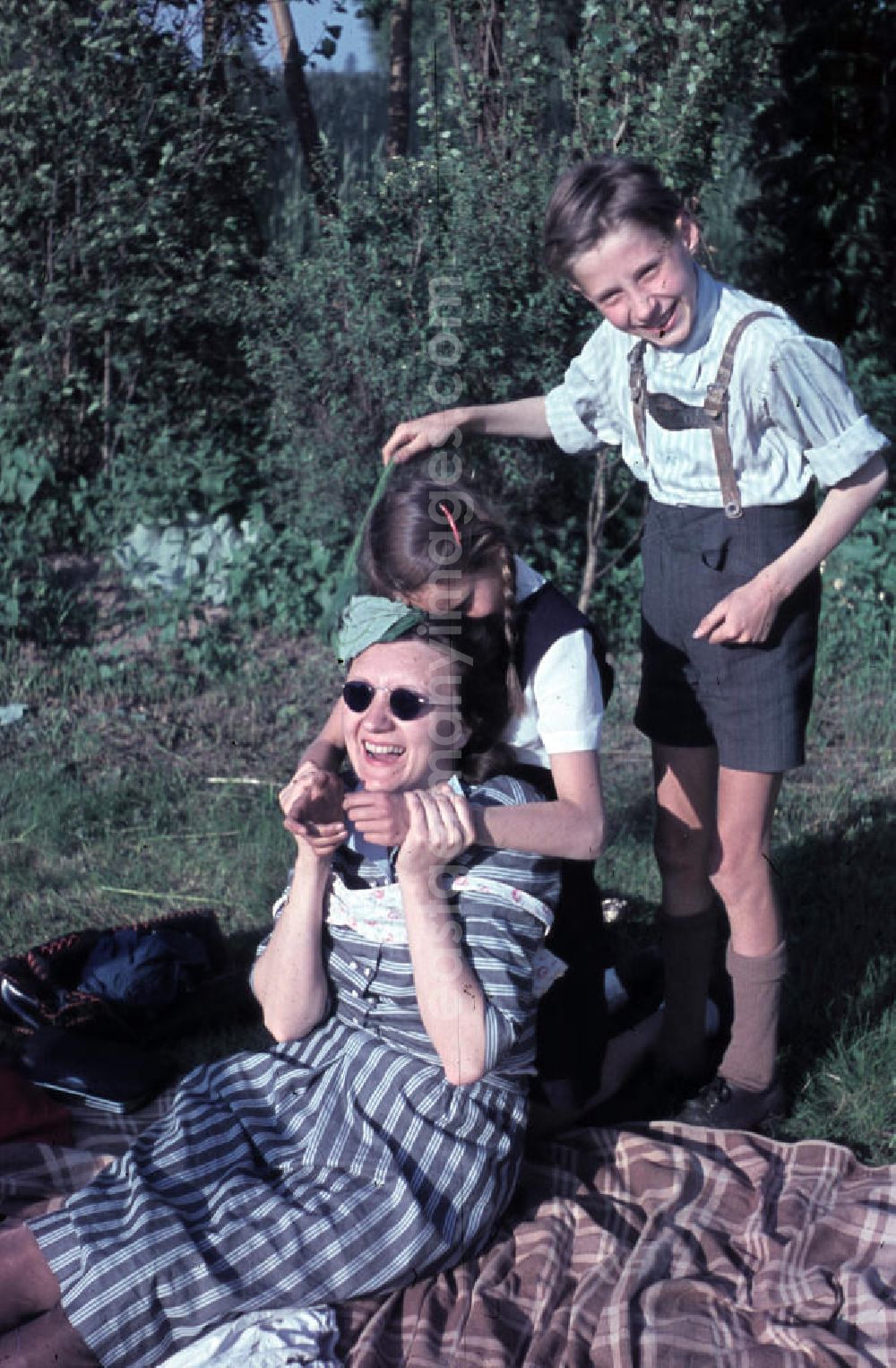 GDR picture archive: Leuna - Familie macht Faxen auf einer Decke im Freibad. Family make grimaces on a blanket in the open-air bath.