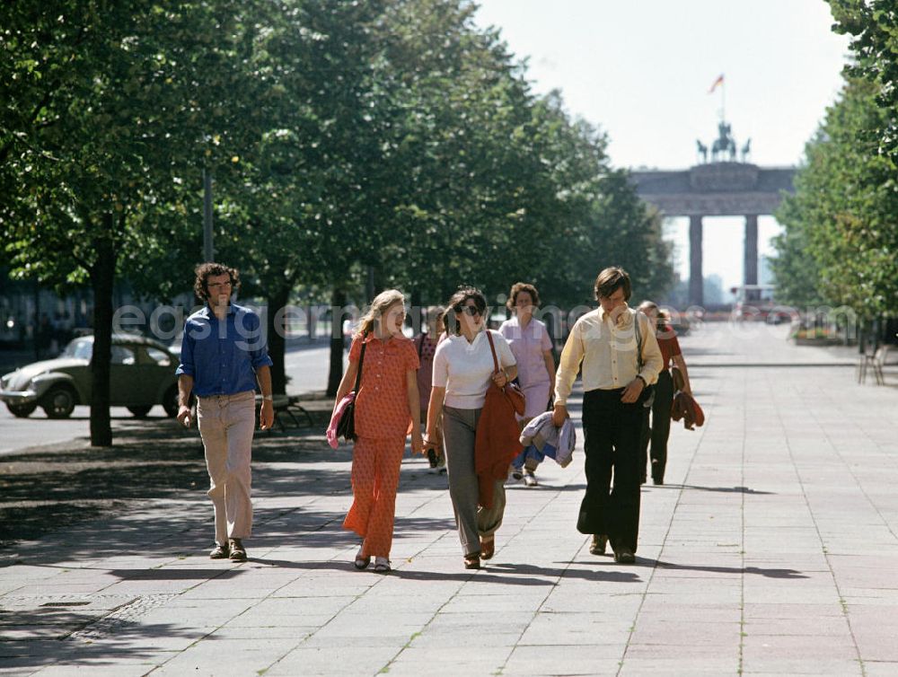 GDR picture archive: Berlin - Touristen flanieren auf der Prachtstraße Unter den Linden in Berlins Mitte und genießen die ersten warmen Sonnenstrahlen des Jahres, im Hintergrund Blick auf das Brandenburger Tor.