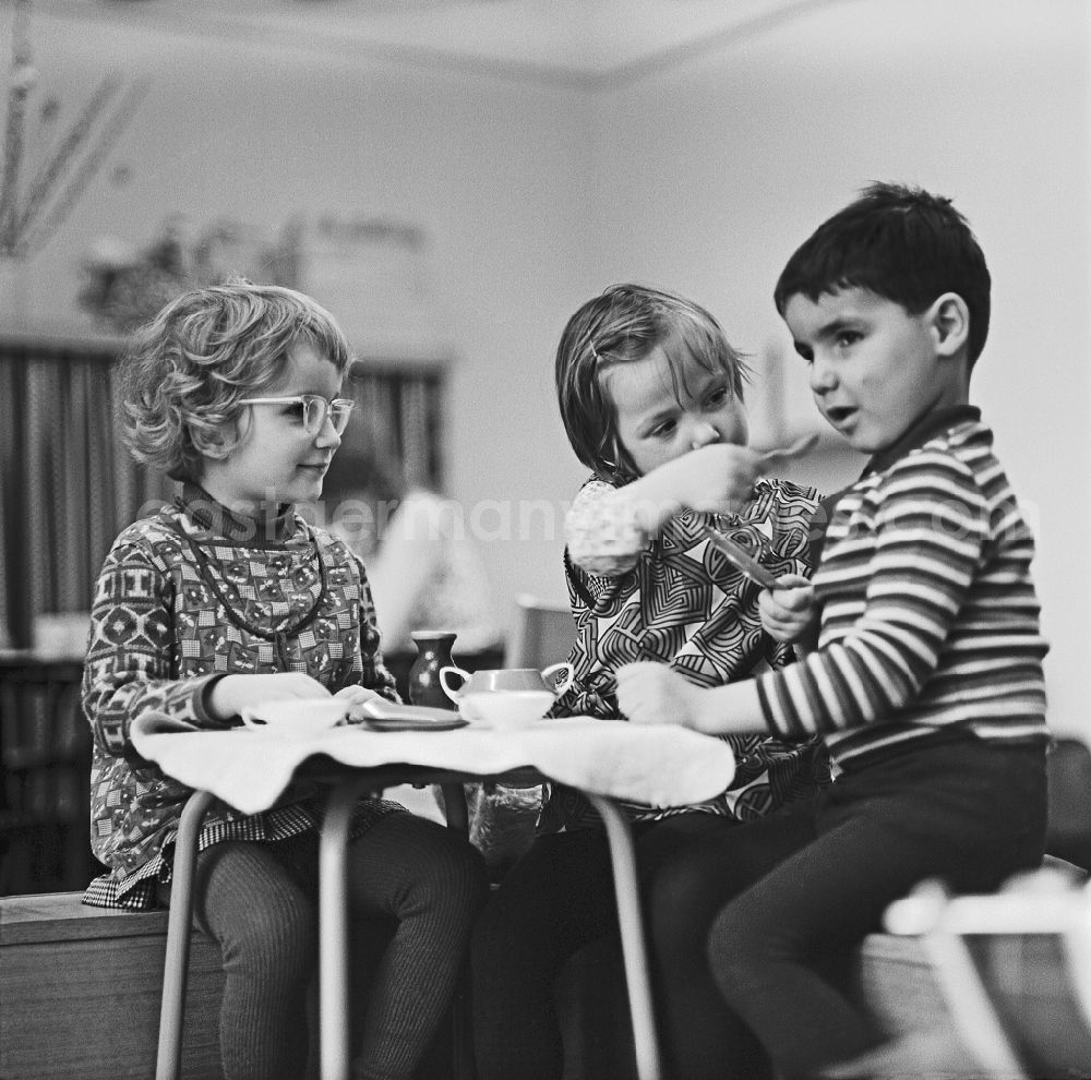 Berlin: Fun and games while reenacting family scenes at a set table with small children in a kindergarten on Konitzer Strasse in the Friedrichshain district of Berlin East Berlin in the area of ??the former GDR, German Democratic Republic