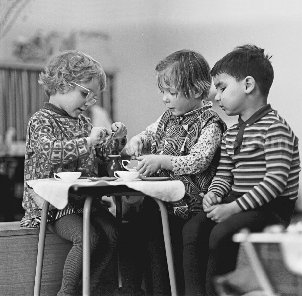 GDR picture archive: Berlin - Fun and games while reenacting family scenes at a set table with small children in a kindergarten on Konitzer Strasse in the Friedrichshain district of Berlin East Berlin in the area of ??the former GDR, German Democratic Republic