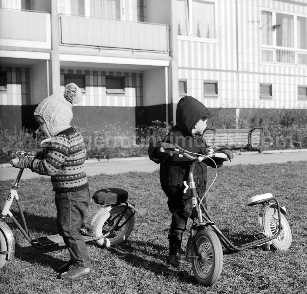 GDR picture archive: Berlin - Children playing with their pneumatic scooters in a courtyard of a residential area in Berlin, the former capital of the GDR, German Democratic Republic
