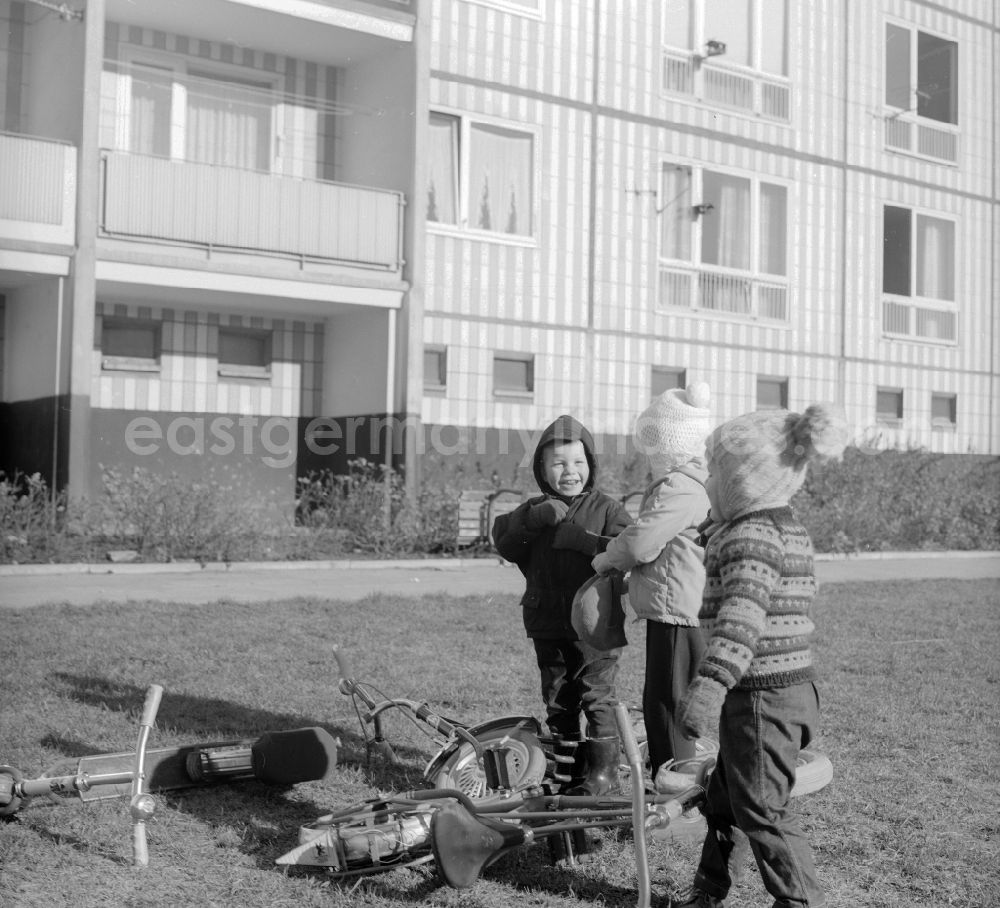 GDR photo archive: Berlin - Children playing with their pneumatic scooters in a courtyard of a residential area in Berlin, the former capital of the GDR, German Democratic Republic