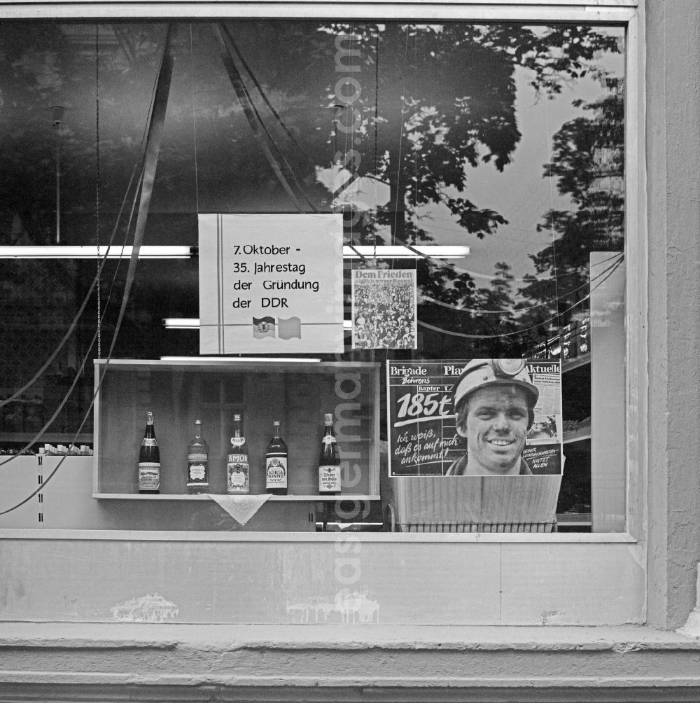 Bautzen: Ideologically oriented slogan and lettering on poster advertising in a shop window for alcohol and spirits in Bautzen in GDR