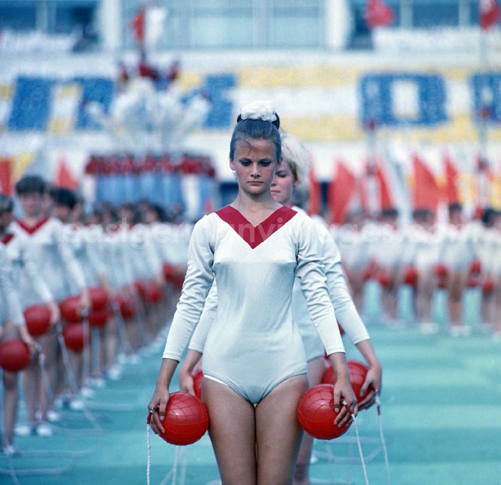 GDR photo archive: Leipzig - Athletes at the opening ceremony in Leipzig's Central Stadium during the V. Gymnastics and Sports Festival of the GDR in the district Mitte in Leipzig in the state Saxony on the territory of the former GDR, German Democratic Republic. They are performing gymnastic exercises with red balls