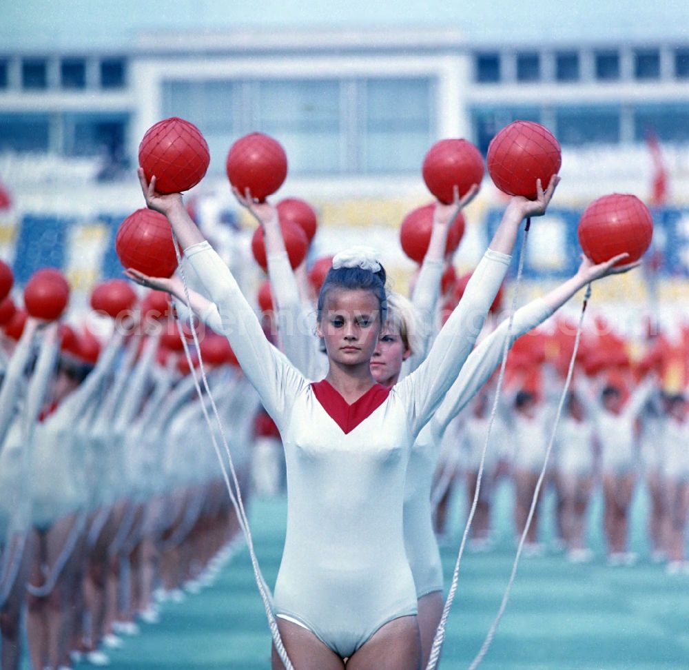 GDR picture archive: Leipzig - Athletes at the opening ceremony in Leipzig's Central Stadium during the V. Gymnastics and Sports Festival of the GDR in the district Mitte in Leipzig in the state Saxony on the territory of the former GDR, German Democratic Republic. They are performing gymnastic exercises with red balls