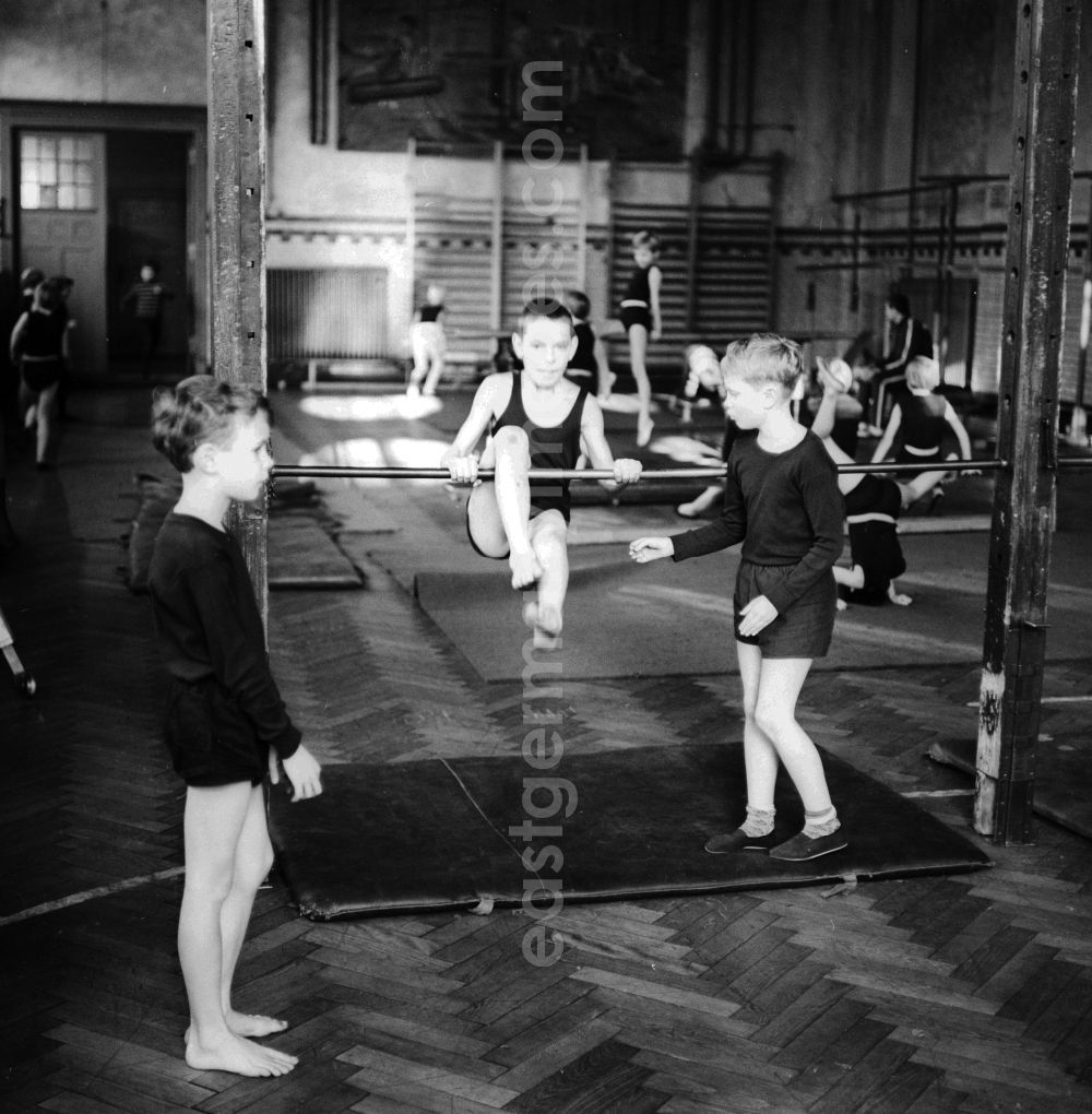 GDR picture archive: Berlin - Physical education - gymnastics in the lower grades in Berlin. Here students on the horizontal bar