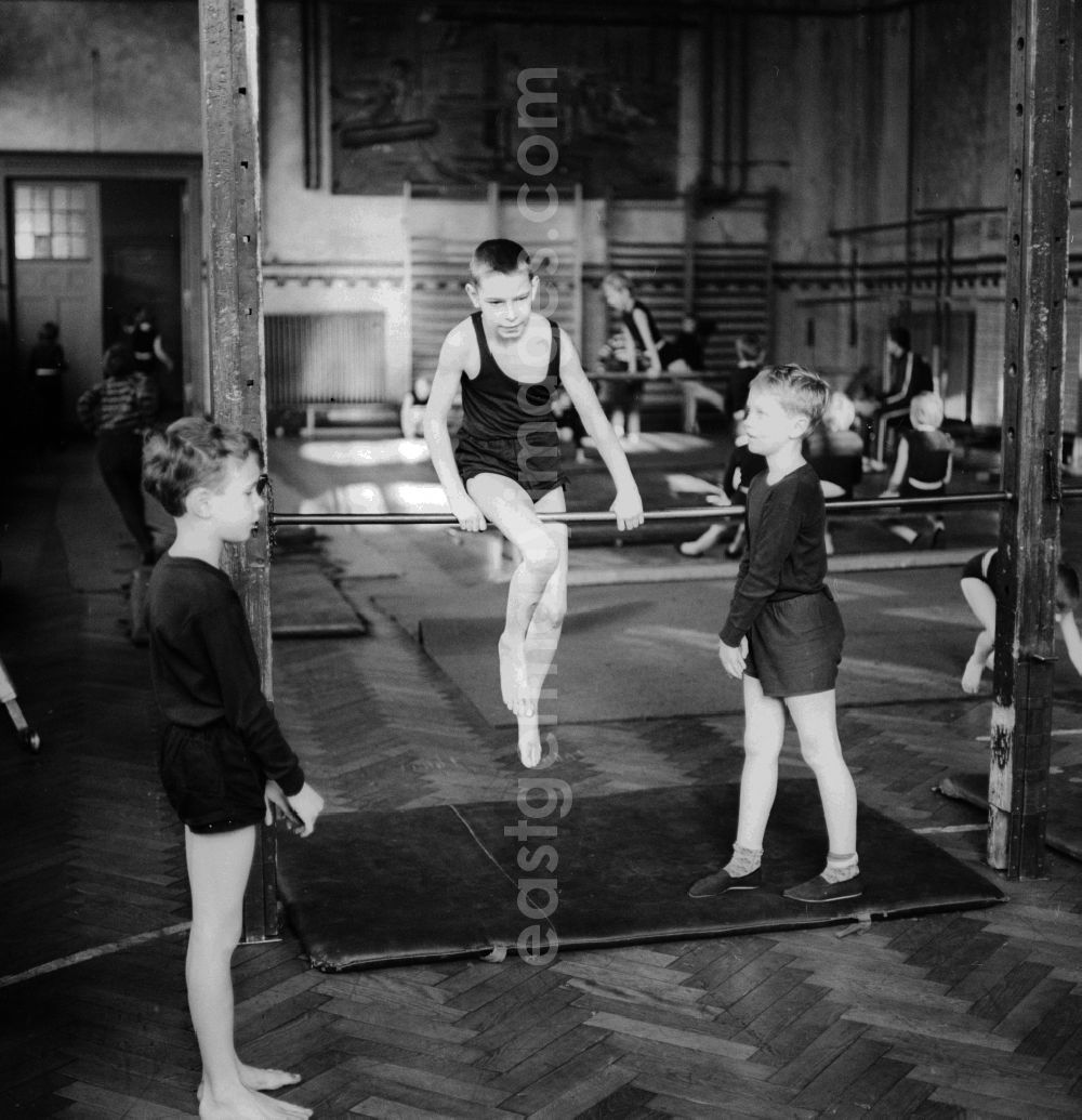 Berlin: Physical education - gymnastics in the lower grades in Berlin. Here students on the horizontal bar