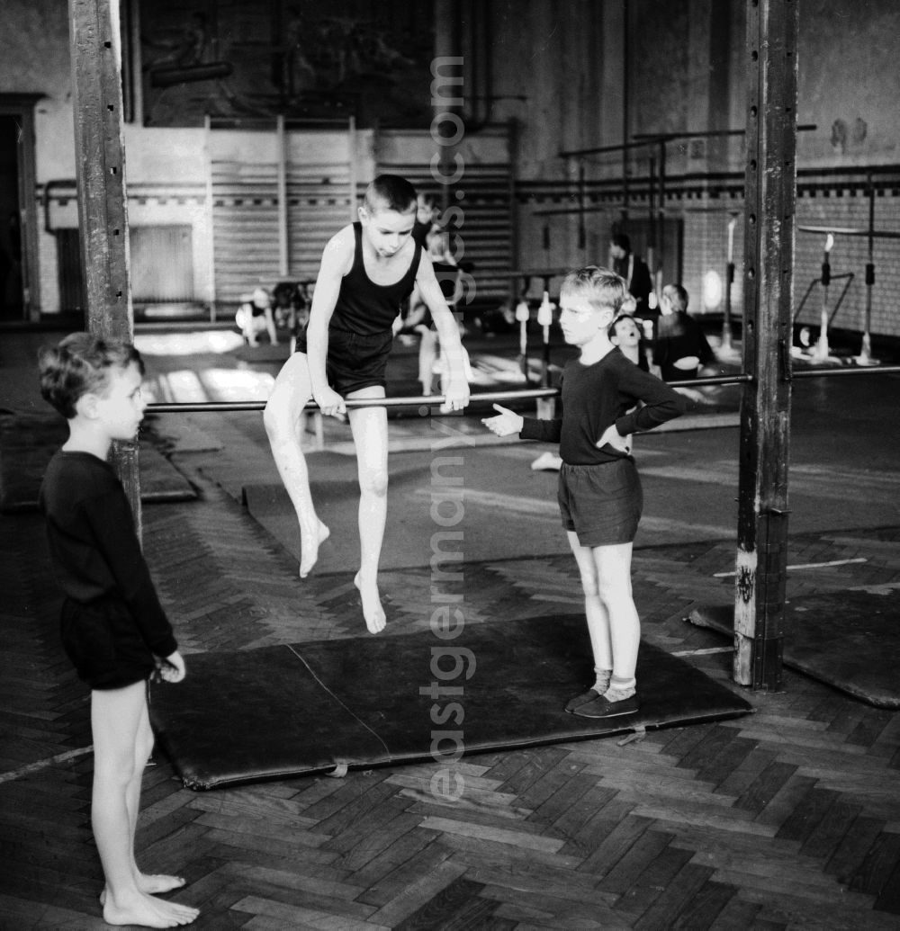 GDR image archive: Berlin - Physical education - gymnastics in the lower grades in Berlin. Here students on the horizontal bar
